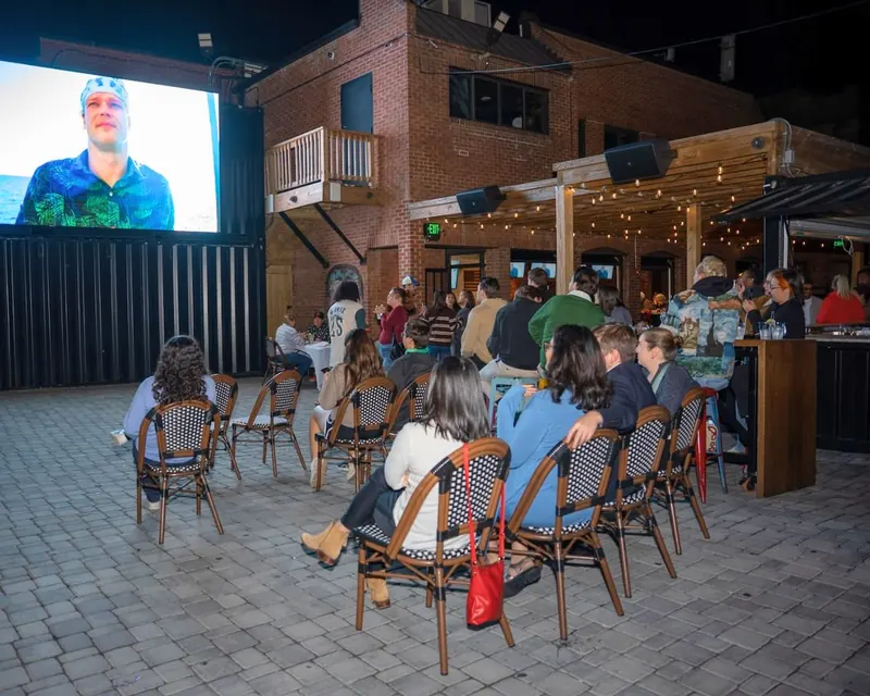 Rows of seats facing the big screen on the Purple Patio at night